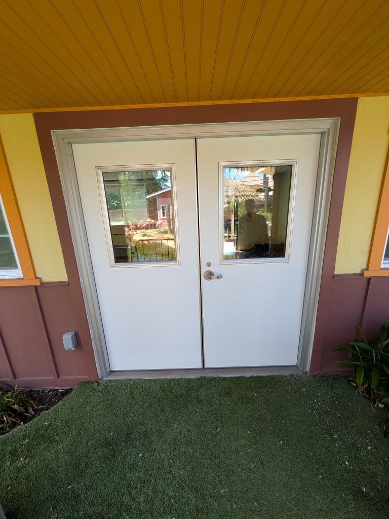 White commercial double doors with glass lites at a building entrance