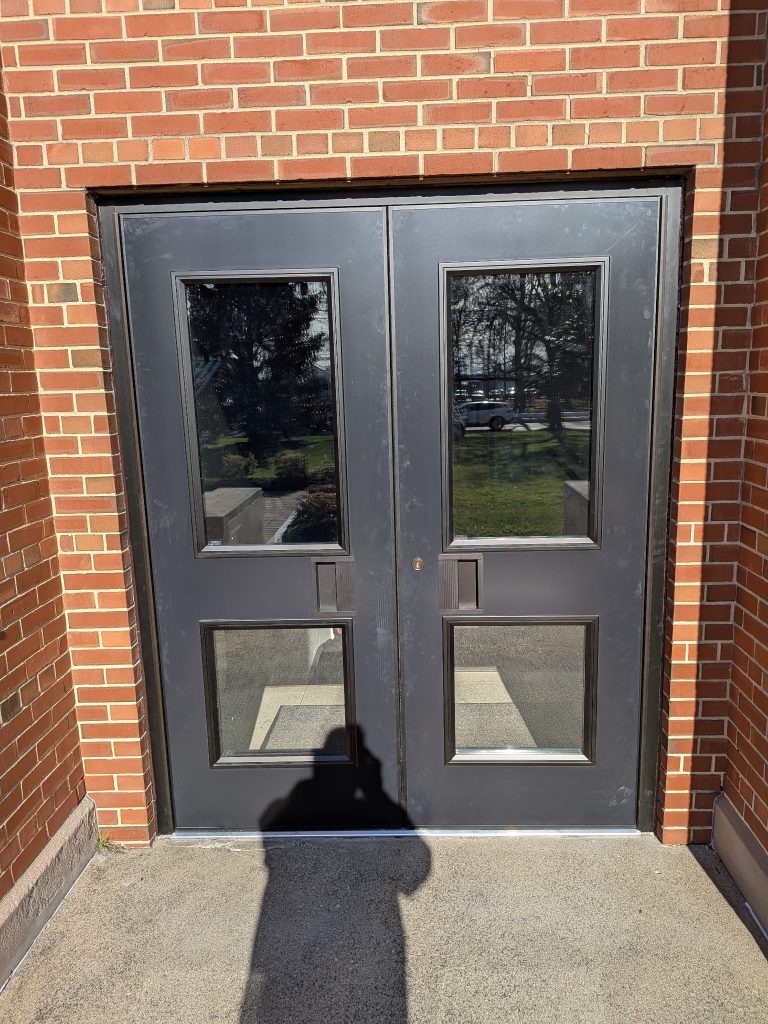 Commercial double steel doors with vision lites on a brick building